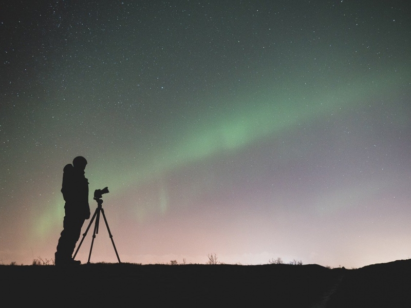 Silueta de un hombre con un telescopio observando el cielo. 