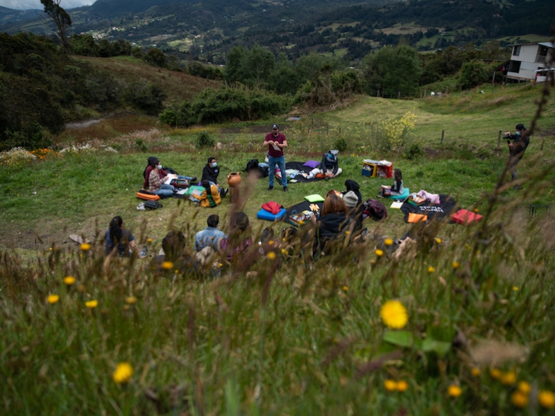 Jóvenes y niños en un campo hablando con mediadior del Planetario. 