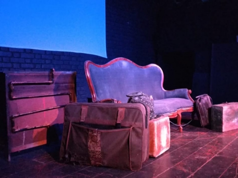 un sofá y unas maletas en el escenario
