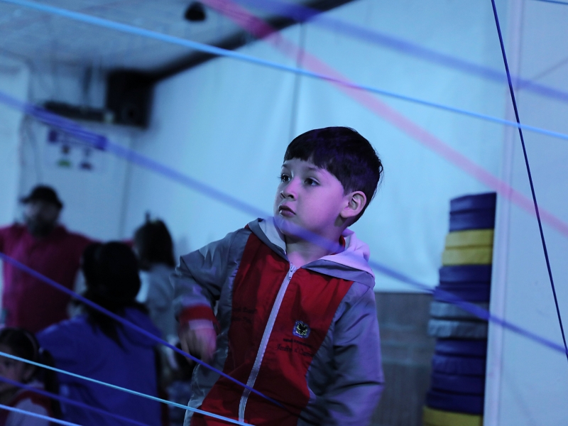 Niño jugando con hilos de color