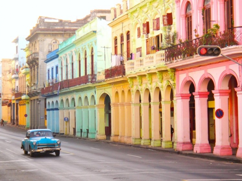 Fotografía de casas caribeás de colores y carro antiguo