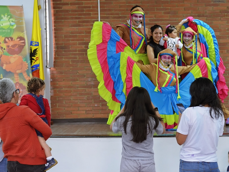 Artistas escénicos del Programa Nidos tomándose fotos con familias