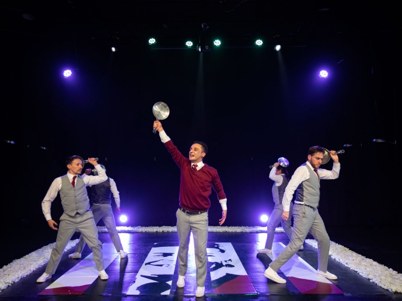 Escena de obra de teatro con jóvenes de colegio de pie