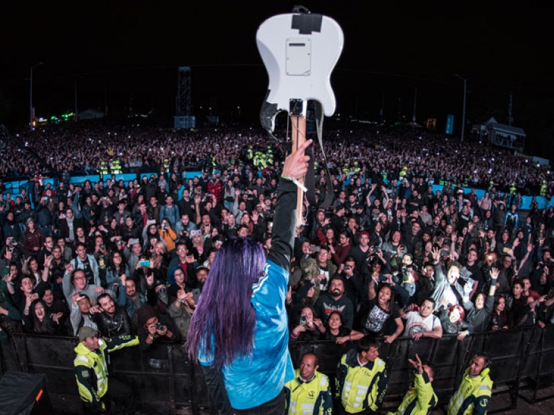 Guitarrista con instrumento en el aire frente a multitud de Rock al Parque