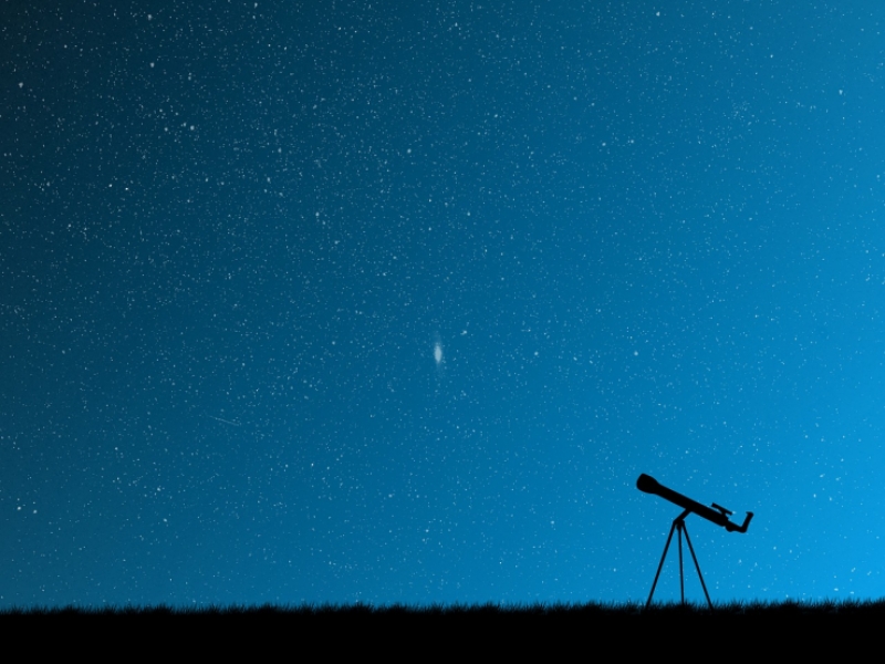 Cielo azul con estrellas y un telescopio en el suelo. 