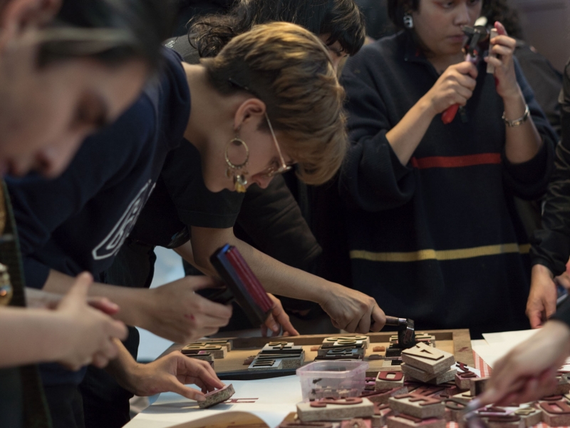 Un grupo de personas elaborando grabados sobre una mesa