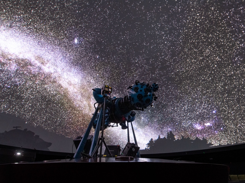 Proyector óptico mecánico en el domo con proyección del cielo de fondo. 