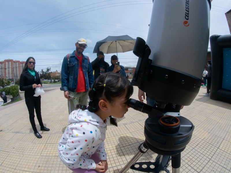 Imagen de niños observando por un telescopio 