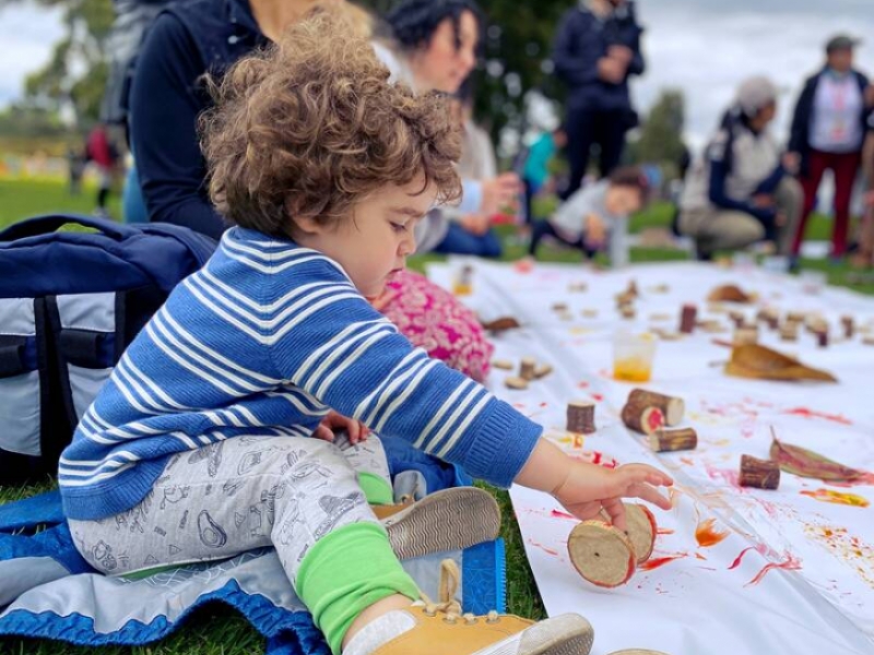 Niña jugando con fichas de madera y pintura en el parque