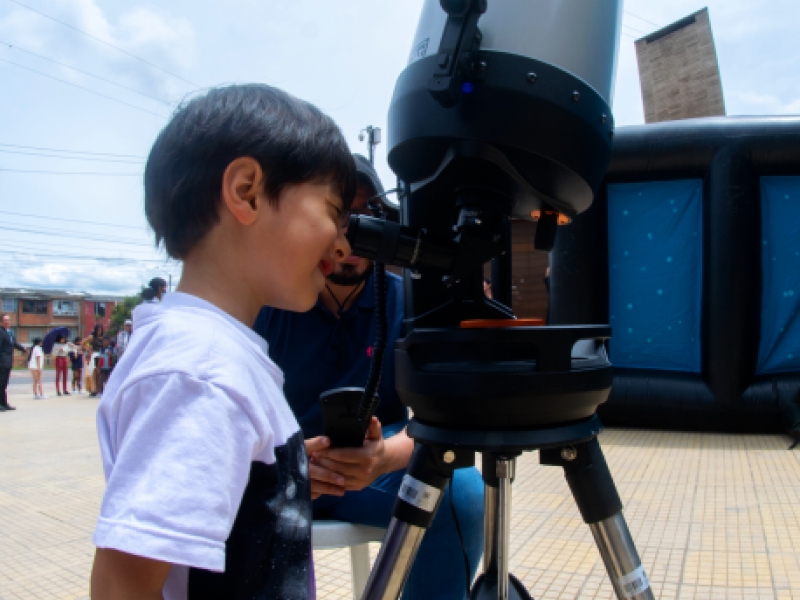 Niño mirando por telescopio