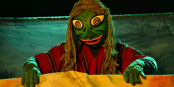Personaje vestido de rana verde con ruana roja