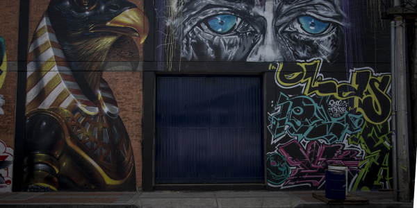 Dibujos de águila y ojos azules en una pared de la ciudad