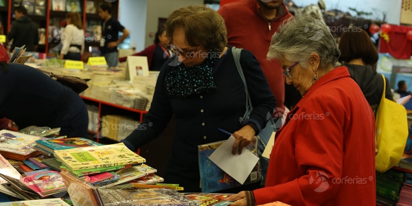 Mujeres viendo libros en estante Corferias - FILBo