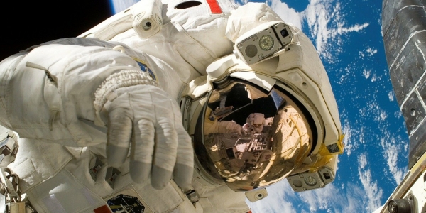 Astronauta en traje espacial con la Tierra de fondo. 