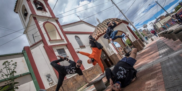 Cuatro jóvenes bailando hip hop frente a una iglesia_Serenata Rap 2020