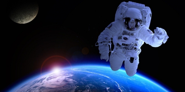 Cosmonauta flotando encima de la Tierra en el espacio. 