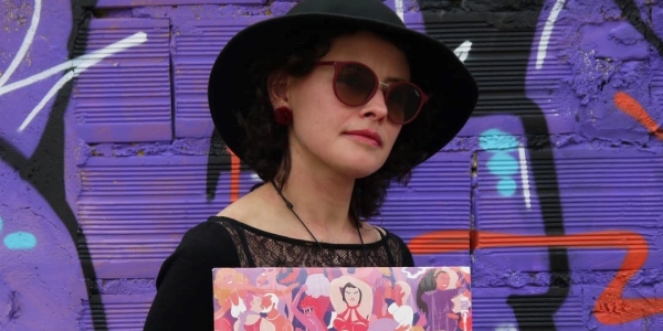Mujer posando para la foto con disco en la mano, en fondo violeta