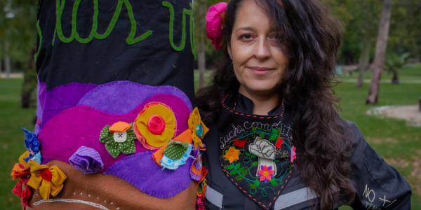 Mujer sosteniendo su bordado en un parque de día