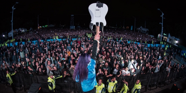 Guitarrista con instrumento en el aire frente a multitud de Rock al Parque