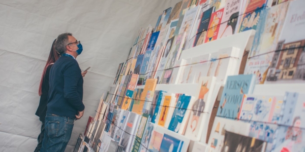 Dos personas viendo un muro con libros 