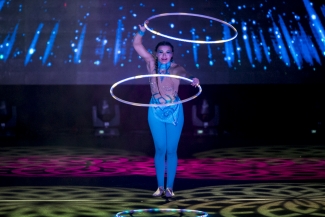 Artista con traje azul haciendo una acto con aros