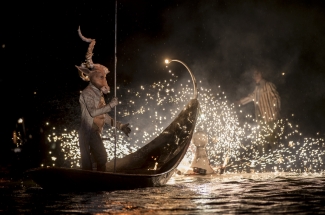 Góndola y actor - unicornio con luces sobre el lago.