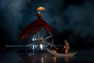 Mujer sobre rueda gigante sobre el lago y actor en góndola.