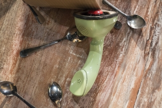 Telefono  verde sobre el piso, con cucharas al rededor