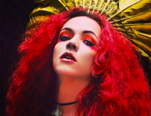 Mujer con pelo rojo y corona de pluma amarillas