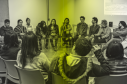 Grupo de personas reunidas en circulo haciendo un tejido