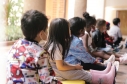 Fila de niños sentados en el piso