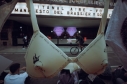 Ropa interior femenina con escritos colgada en cuerdas frente a un teatro