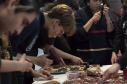 Un grupo de personas elaborando grabados sobre una mesa