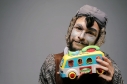 Artista con traje y juguete de bus en la mano