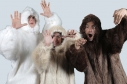 Artistas con trajes de peluche juntos y levantando sus manos
