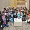 Un grupo de personas se reunen para mostrar ejemplares de una antología literaria.