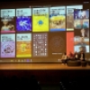 En un escenario se proyecta una pantalla en el que un panel expone las publicaciones realizadas por la Línea ACT del idartes. El escenario hace parte de la programación de la vigesimo cuarta edición del Festival de la Imagen en Manizales.