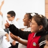 Tres niños de perfil, sonrien ante algo que ven
