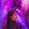Una niña baila en medio de humo de colores