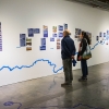Un hombre y una mujer repasan la línea del tiempo colocada en la exposición de Ciudad de Agua